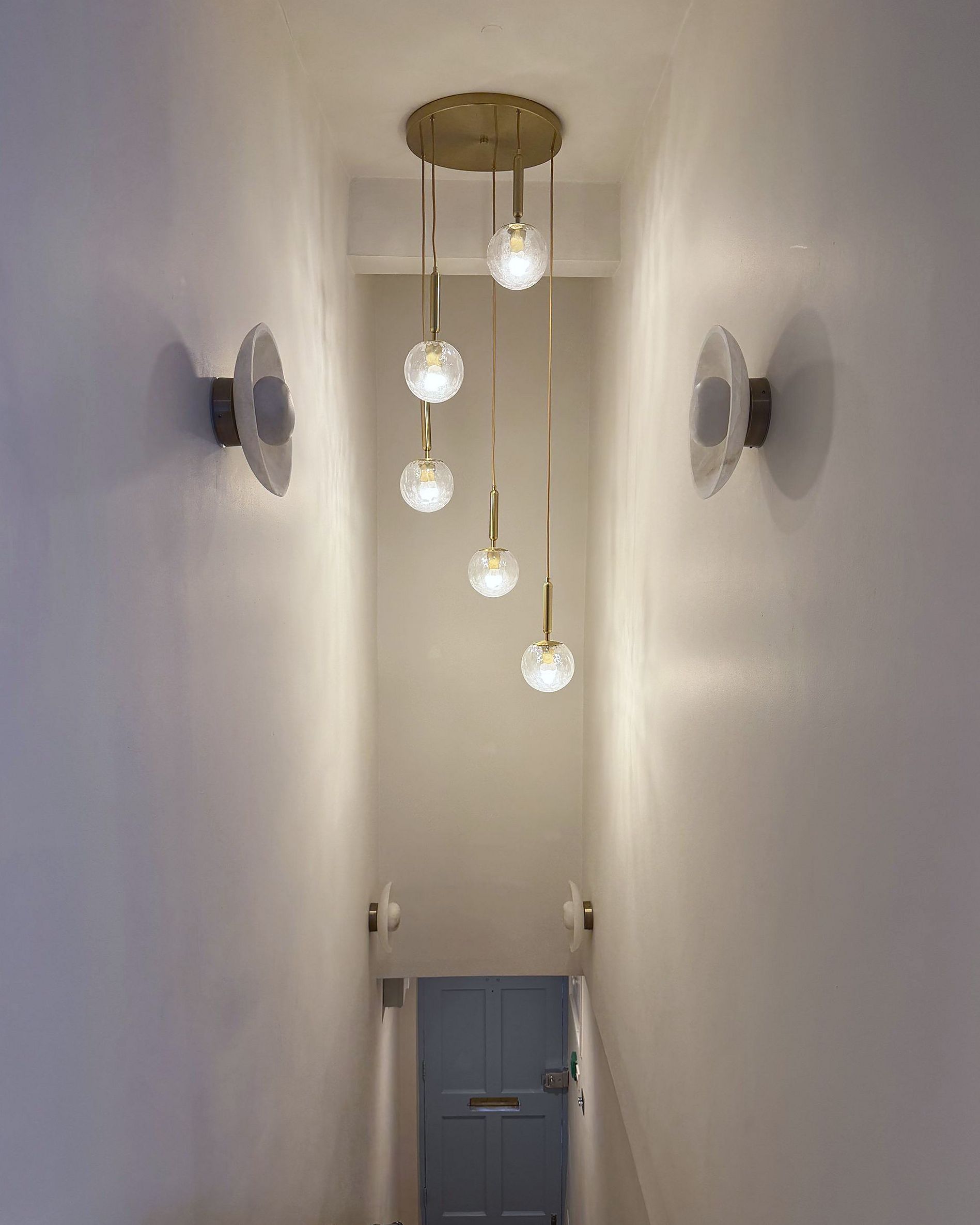 Pendant lights above the stairs down to the front door of DROM Clinic